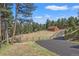 Detached garage or workshop in a wooded setting with a paved driveway at 28940 Pinewood Vista Dr, Evergreen, CO 80439
