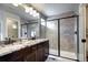 Modern bathroom features a double vanity, granite countertops, and a glass-enclosed shower at 4100 Albion St # 1509, Denver, CO 80216