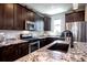 Kitchen featuring granite countertops, stainless steel appliances, and dark wood cabinetry at 4100 Albion St # 1509, Denver, CO 80216