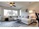 Bright living room featuring a large sectional sofa, ceiling fan, and large windows at 4100 Albion St # 1509, Denver, CO 80216