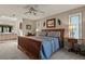 Comfortable bedroom with a wooden bed frame, fan, and view into the ensuite bathroom and vanity area at 1503 W Briarwood Ave, Littleton, CO 80120