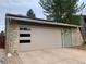 Attached garage with modern door design and exterior stone and vinyl siding details at 1503 W Briarwood Ave, Littleton, CO 80120