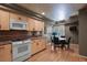 Kitchen view of breakfast nook table, wood cabinets, backsplash, and modern appliances at 1503 W Briarwood Ave, Littleton, CO 80120