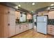 Bright kitchen featuring granite countertops, a white refrigerator, and hardwood floors at 1503 W Briarwood Ave, Littleton, CO 80120