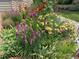 Lush landscaping with a variety of colorful flowers and foliage in a garden bed at 1503 W Briarwood Ave, Littleton, CO 80120