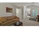 Cozy living room with a tan couch, a patterned rug, and a walk-through to another room at 1503 W Briarwood Ave, Littleton, CO 80120