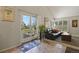 Bright living room featuring a black leather sofa and a door to the backyard at 1503 W Briarwood Ave, Littleton, CO 80120