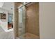 Clean shower with glass door and tile surround, complemented by nearby shelving and hallway views at 1503 W Briarwood Ave, Littleton, CO 80120