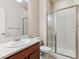 Well-lit bathroom with glass shower, a toilet and single sink with stone countertop at 19368 E Quincy Pl, Aurora, CO 80015