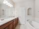 Well-lit bathroom featuring dual sinks, a soaking tub, and modern fixtures at 19368 E Quincy Pl, Aurora, CO 80015