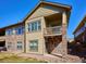 Multi-story exterior with stone and siding detail, a small balcony, and basement walkout at 19368 E Quincy Pl, Aurora, CO 80015