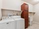 Functional laundry room with washer, dryer, storage cabinet, and a utility sink at 19368 E Quincy Pl, Aurora, CO 80015
