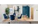 Elegant dining area with a glass-top table, stylish blue chairs, and modern artwork at 2314 S University Blvd, Denver, CO 80210