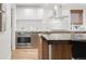 Modern kitchen featuring stainless steel appliances, sleek cabinetry, and a large island with bar stools at 2314 S University Blvd, Denver, CO 80210