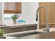 Close-up of a modern kitchen sink with stylish faucet, showcasing the elegant countertop and built-in cabinetry at 2314 S University Blvd, Denver, CO 80210