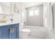 Updated bathroom with a navy vanity, geometric tile shower, and white fixtures at 1070 W Oxford Ave, Englewood, CO 80110