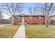 Brick ranch house with a landscaped yard and walkway at 1070 W Oxford Ave, Englewood, CO 80110