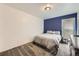Bedroom featuring neutral tones, plush carpet, a blue accent wall and a window at 3663 S Sheridan Blvd # 14, Denver, CO 80235