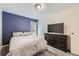 Bedroom featuring a tv on top of a dresser, plush carpet, and a blue accent wall at 3663 S Sheridan Blvd # 14, Denver, CO 80235