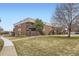 Brick condo building with stairs to the units and a grassy yard with mature trees in a quiet neighborhood at 3663 S Sheridan Blvd # 14, Denver, CO 80235