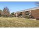 Brick condo building featuring stairs to the units, satellite dishes, and green grass in the yard at 3663 S Sheridan Blvd # 14, Denver, CO 80235
