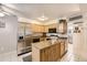 Kitchen view with stainless steel refrigerator, wooden cabinets, island, and black oven at 3663 S Sheridan Blvd # 14, Denver, CO 80235