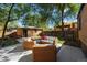 Inviting backyard patio with wicker furniture, complemented by a well-maintained detached garage and mature trees at 2088 Kearney St, Denver, CO 80207