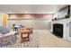 Basement seating area featuring a decorative fireplace, exposed brick, and neutral carpet at 2088 Kearney St, Denver, CO 80207