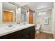 Modern bathroom featuring a double vanity, wood floors, and updated lighting fixtures at 2088 Kearney St, Denver, CO 80207