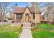 Charming brick home featuring mature landscaping, a cozy front porch, and a well-manicured lawn at 2088 Kearney St, Denver, CO 80207