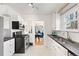 Updated kitchen with stainless steel appliances, white cabinets, and view into the dining room at 2088 Kearney St, Denver, CO 80207