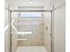 A luxurious walk-in shower has a window and a built-in seat for added comfort at 6132 Hourglass Dr, Brighton, CO 80601