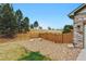 Inviting backyard featuring a wooden fence, gravel area, and open space beyond the property line at 3469 Amber Sun Cir, Castle Rock, CO 80108
