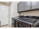 Convenient laundry room features modern washer and dryer, ample storage cabinets, and tiled flooring at 3469 Amber Sun Cir, Castle Rock, CO 80108