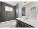 Stylish bathroom featuring dark tile accent wall, large mirror and a shower-tub combination at 3932 S Pagosa St, Aurora, CO 80013