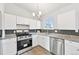 Modern kitchen featuring stainless steel appliances, granite countertops, and bright white cabinets at 3932 S Pagosa St, Aurora, CO 80013