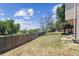 Large backyard with tall wooden fence and mature trees and grass at 5372 E 108Th Pl, Thornton, CO 80233