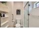 Well-lit bathroom featuring tiled shower with glass door, handy shelving, and modern fixtures at 65 Avocet Ct, Longmont, CO 80501