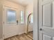 Bright entryway featuring a glass paneled front door, wood floors, and a charming arched mirror at 65 Avocet Ct, Longmont, CO 80501
