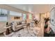 Cozy living room with large windows, stylish decor, and an open layout to the dining area and kitchen at 65 Avocet Ct, Longmont, CO 80501