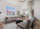 Open-concept living room leading into the kitchen, featuring modern furniture, hardwood floors, and ample natural light at 795 Nighthawk Cir, Louisville, CO 80027