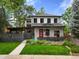 Charming two-story home with stone accents, a red door, and a beautifully landscaped front yard at 2805 S Sherman St, Englewood, CO 80113