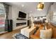 Elegant living room with a stone fireplace, modern lighting, and an open view of the kitchen at 2805 S Sherman St, Englewood, CO 80113