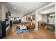 Open-concept living room with hardwood floors, a stone fireplace, and seamless flow to the kitchen at 2805 S Sherman St, Englewood, CO 80113