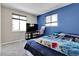 Bedroom with full-size bed, large TV, and blue and beige walls at 5100 Troy St, Denver, CO 80239