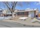 House front with attached garage and snow-covered yard at 5100 Troy St, Denver, CO 80239