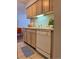 Compact kitchen featuring light wood cabinetry, white dishwasher, and tiled flooring at 7755 E Quincy Ave # 203A6, Denver, CO 80237