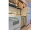 Functional kitchen featuring white appliances, tile backsplash, and light wood cabinets at 7755 E Quincy Ave # 203A6, Denver, CO 80237