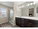 Bright bathroom with a glass-enclosed shower, large mirror, and vanity with storage at 16369 Alberta Dr, Parker, CO 80134