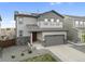 Two-story home featuring stone accents, solar panels, a two-car garage, and a well-maintained lawn at 16369 Alberta Dr, Parker, CO 80134
